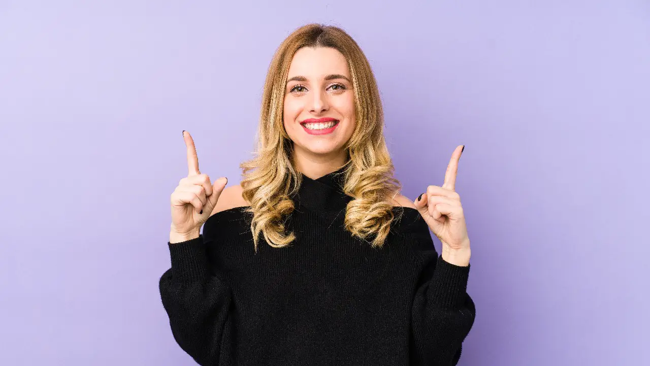 Confident woman pointing two fingers upward