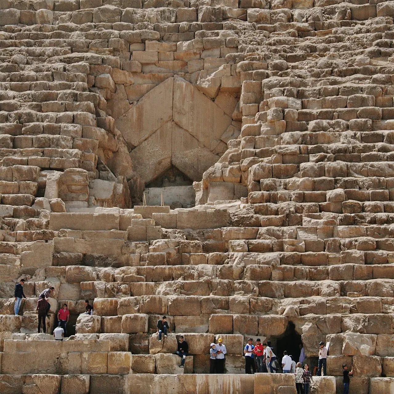 Tourists climbing at the entrance to Khufu (The Great Pyramid) at Giza, Egypt.