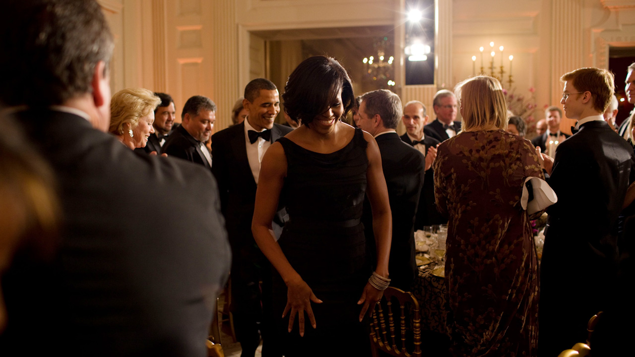 Michelle Obama walking through a crowd at a party