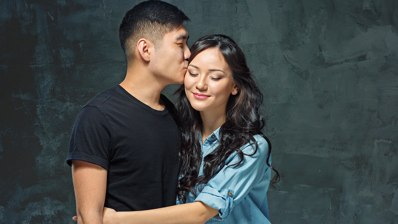 An Asian couple taking a portrait photo at the studio