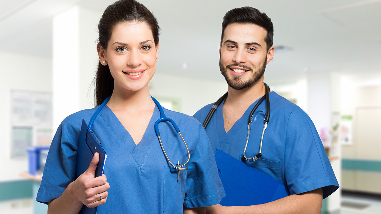 A female and male Nurse Practitioner wearing blue outfits