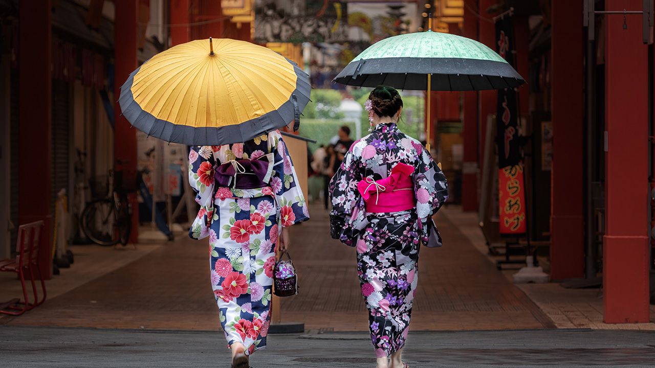 Two women dress in Kimono walk around town