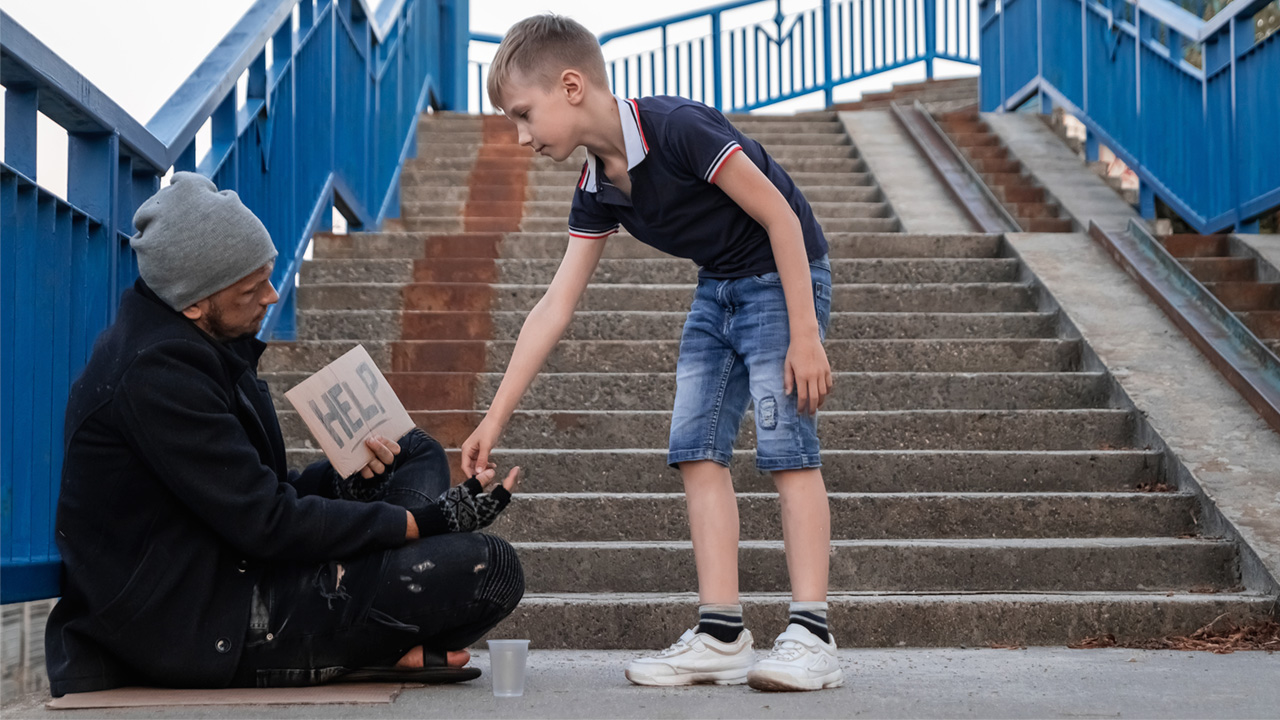 A boy gives a homeless man money