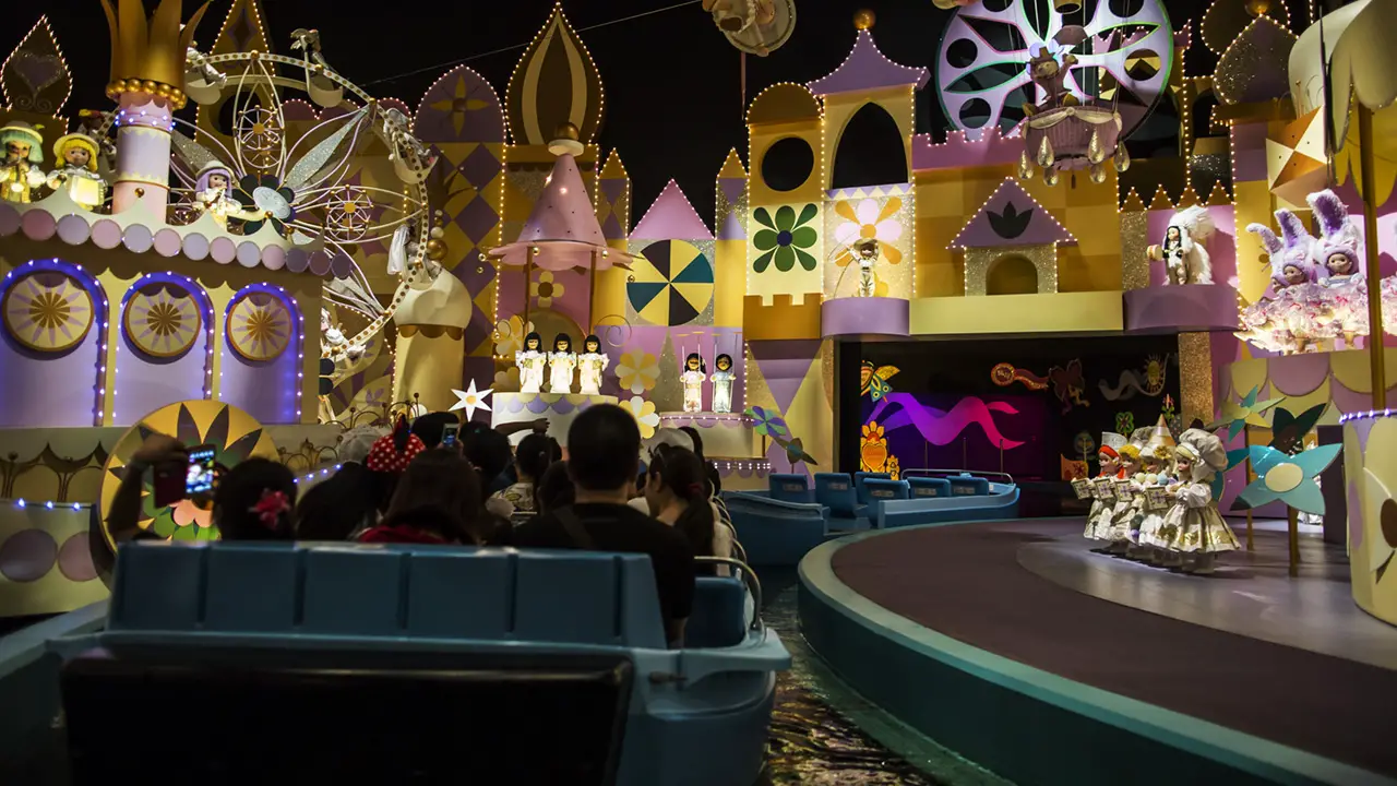 Several visitors ride the It's A Small World attraction