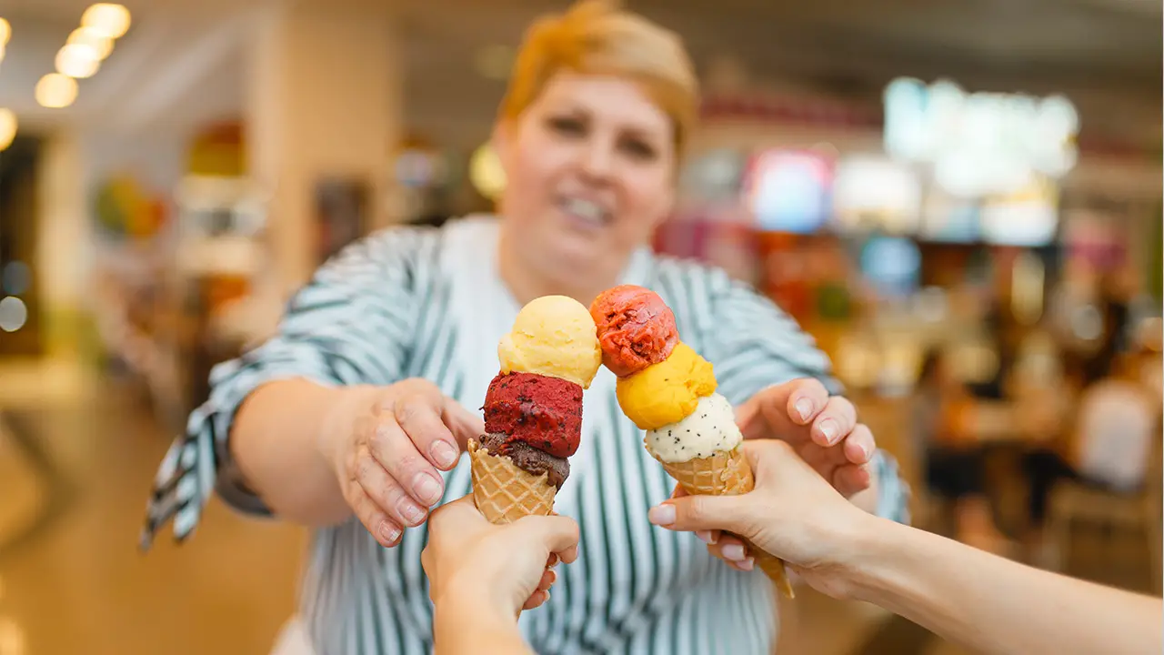 An obese woman is handed two ice creams