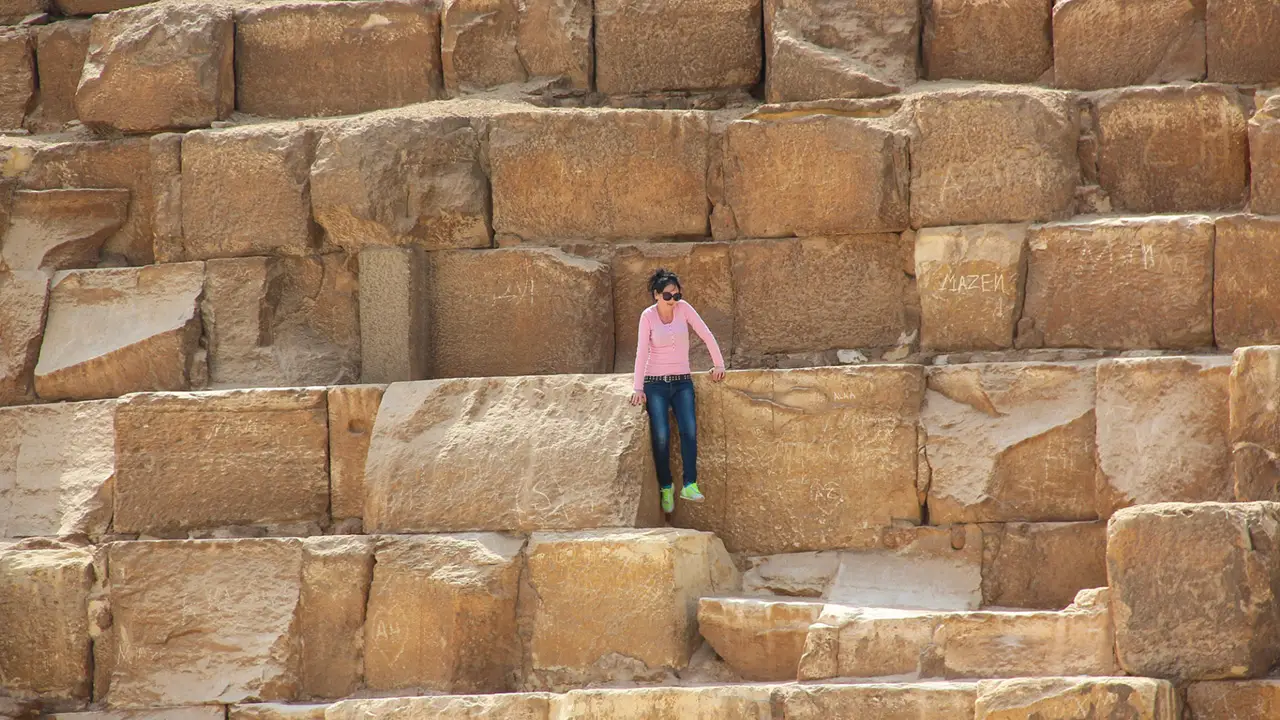 Girl sitting ancient stones Egyptian pyramids