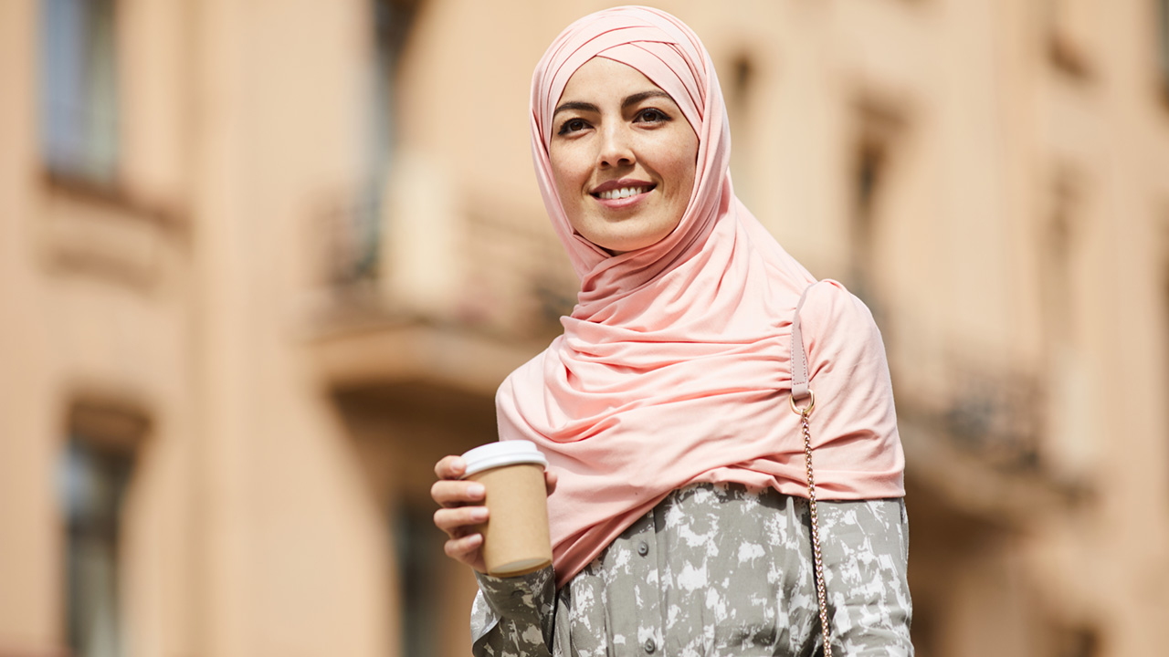 Happy Middle Eastern businesswoman with coffee