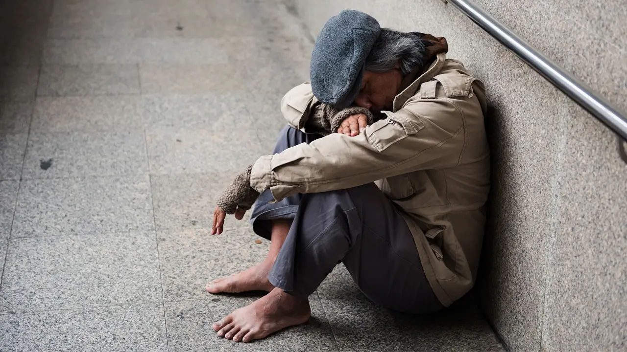 Old beggar homeless dirty man without shoes sitting sleeping walkway