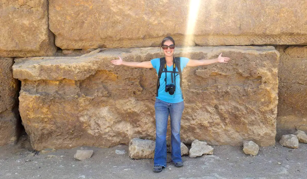 Woman standing next to pyramid stones